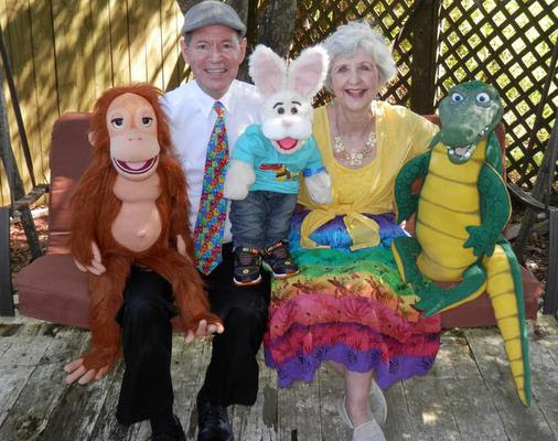 Photo of a man and woman with puppets.